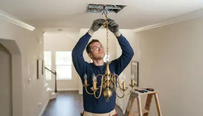 Houston, TX electrician installing and wiring a chandelier to a ceiling box with a safety brace