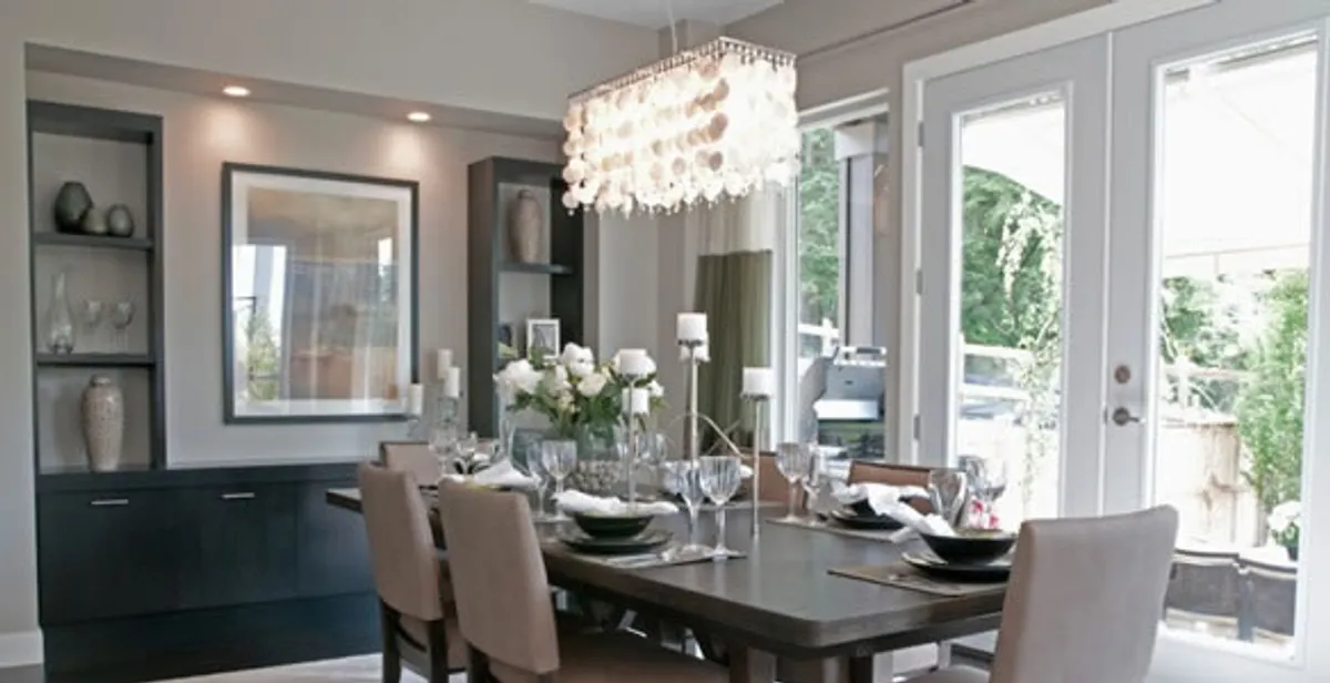 Elegant dining room chandelier installation above table in Houston, TX