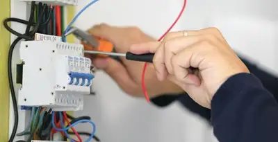 Electrician installing and adjusting circuit breakers in an electrical panel in Houston, TX