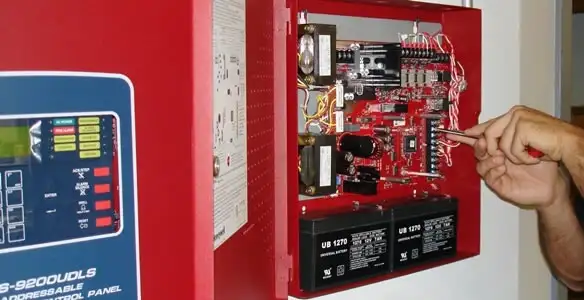 fire alarm installation service showing technician configuring fire alarm control panel in Houston, TX