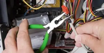 Licensed electrical contractor performing electrical repair with tools in Missouri City, TX