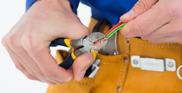 licensed electrician securing electrical wiring with professional tools during service work in Houston, TX