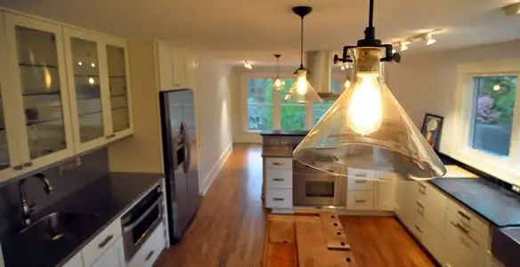 Residential electrician installing modern indoor light fixture in a home in Houston, TX